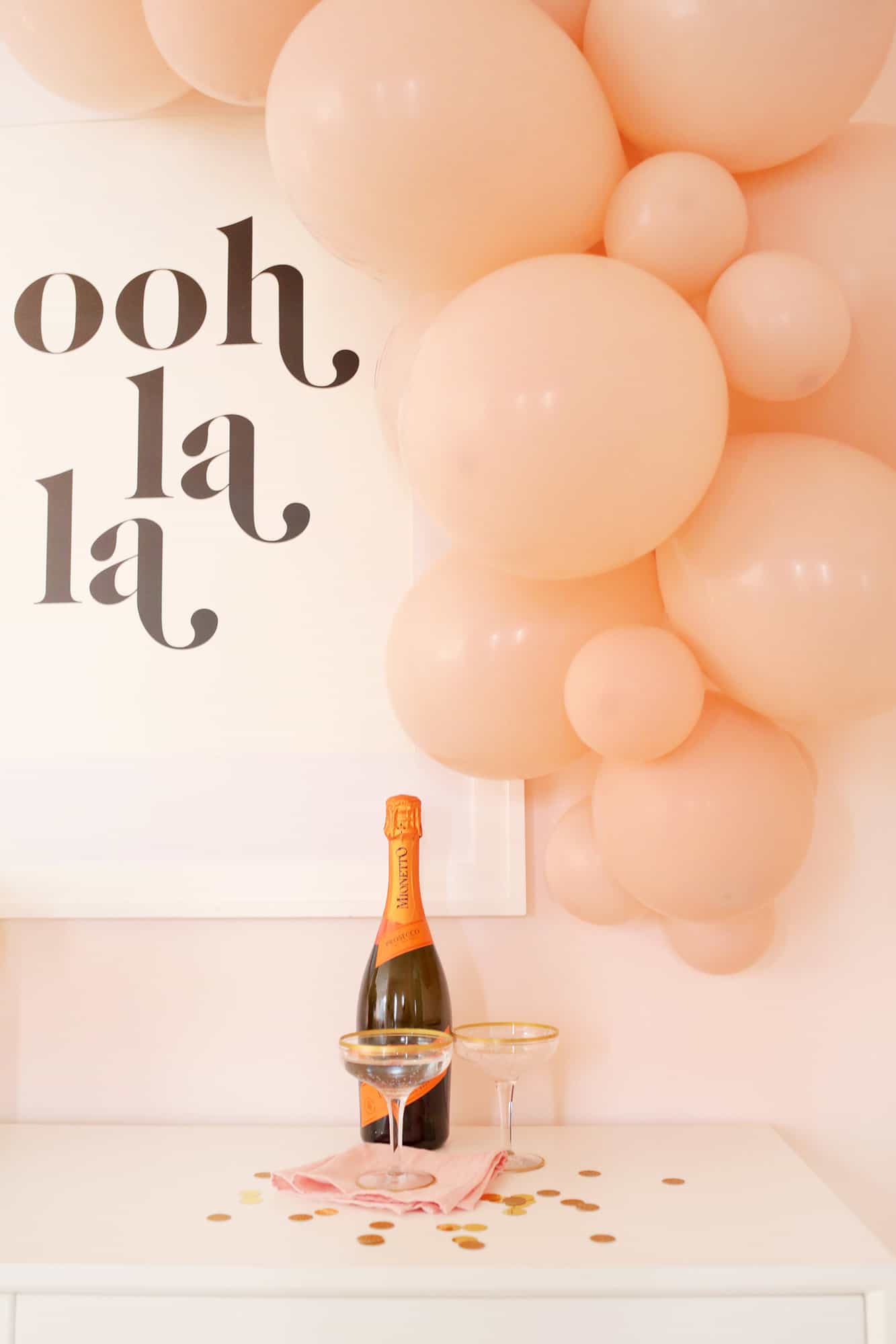 pink balloon garland over table with champagne
