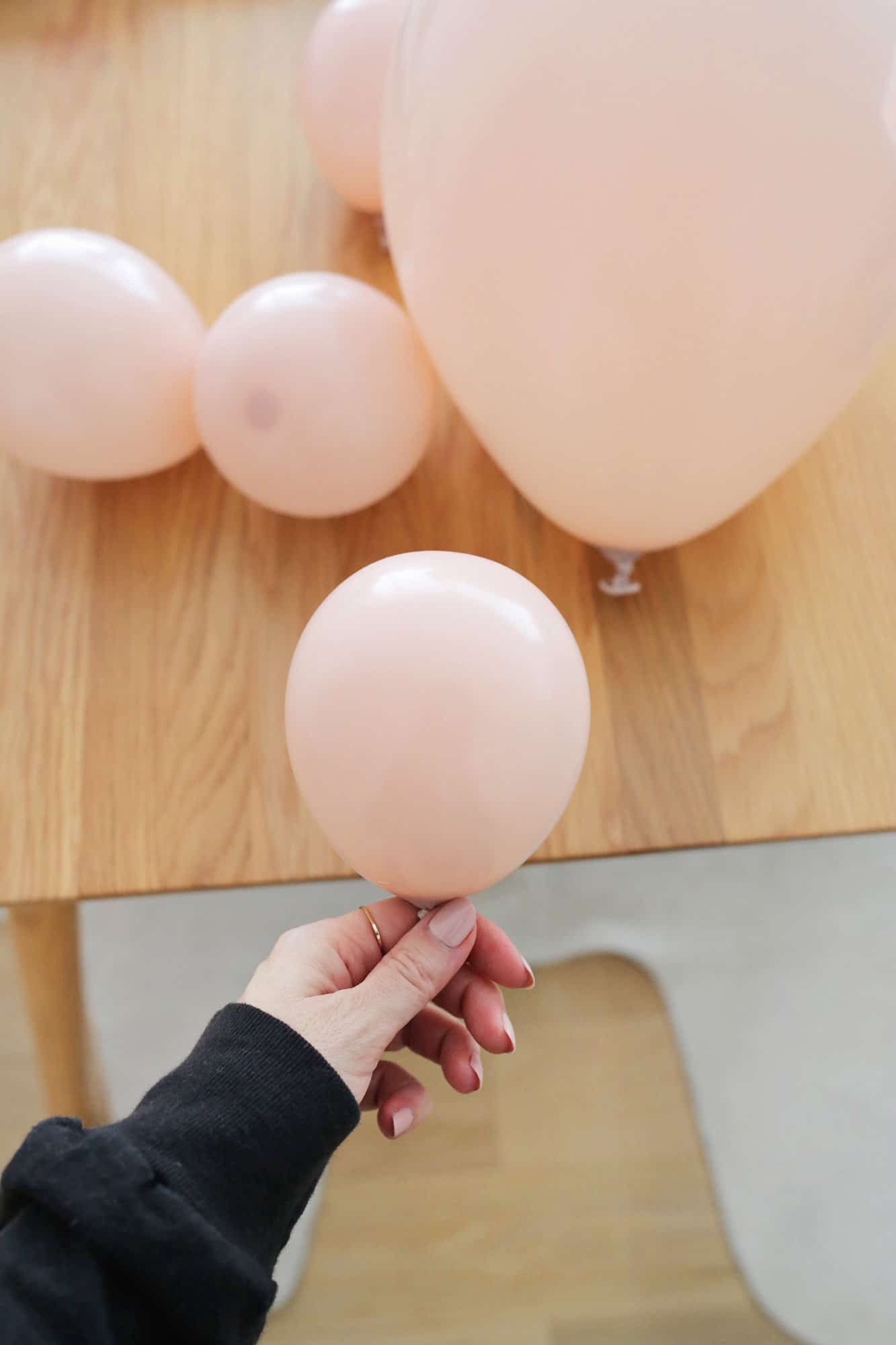 blowing up pink balloons for balloon garland